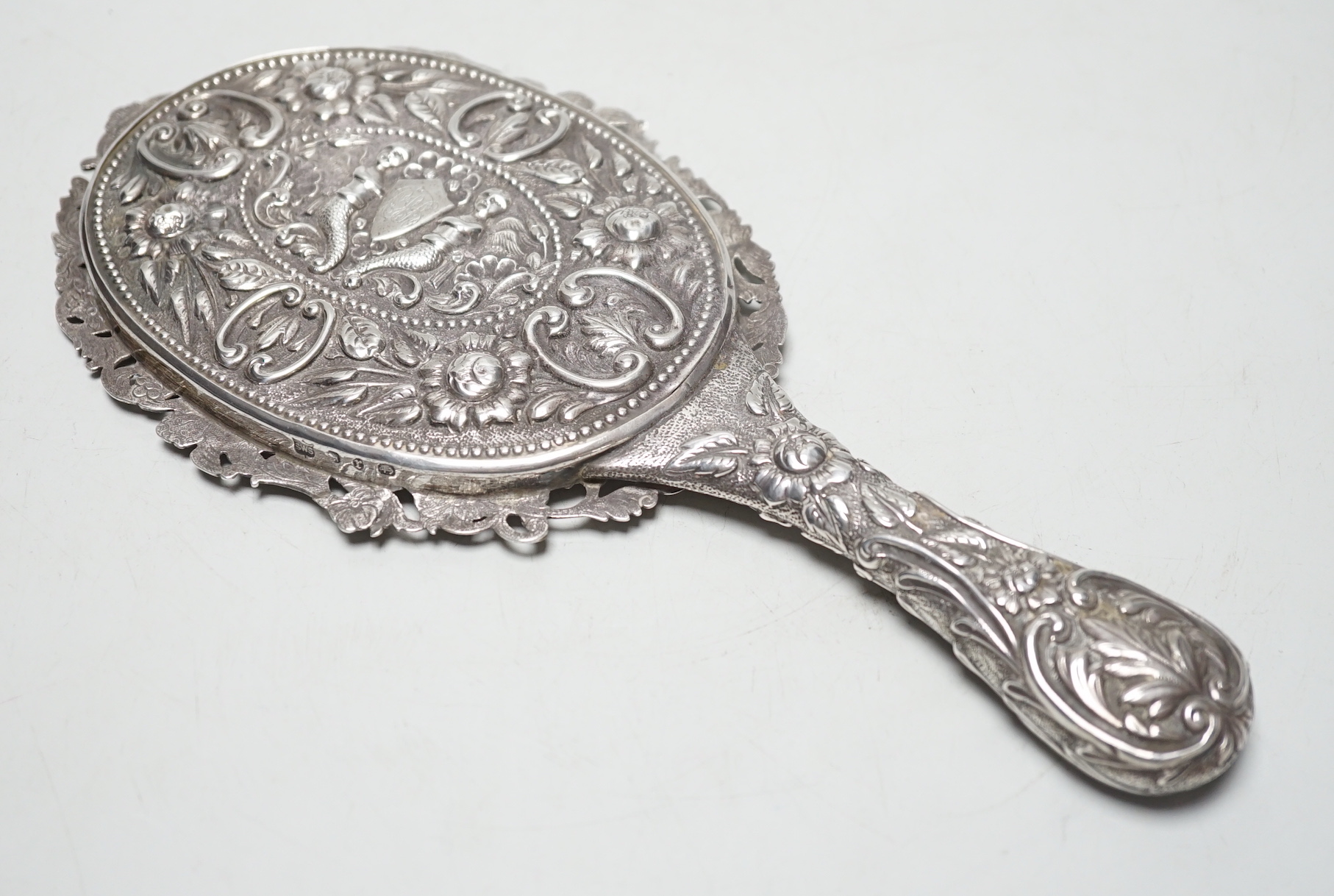 A late Victorian embossed silver hand mirror, Samuel Walton Smith, Birmingham, 1891, 27cm.